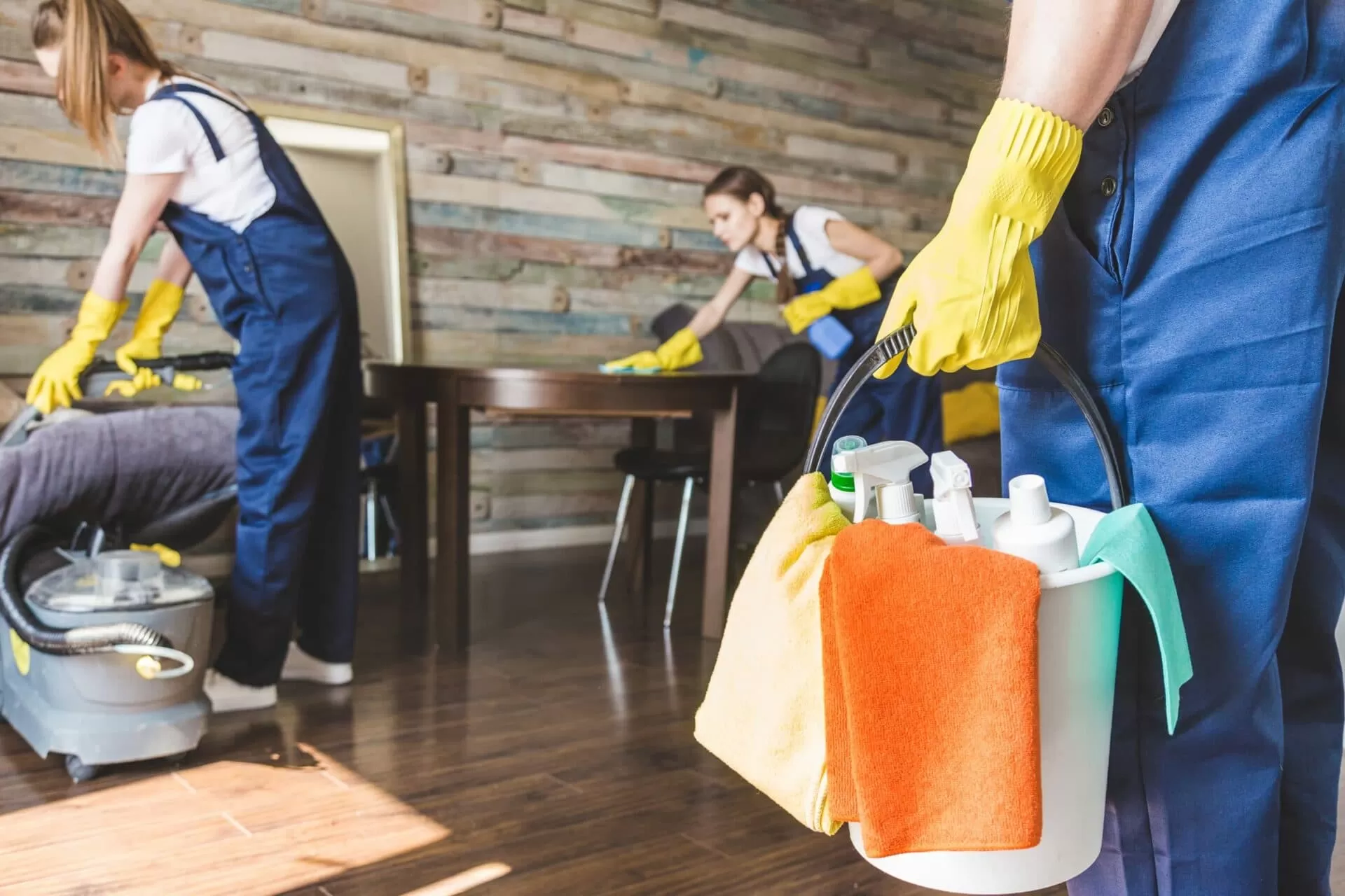 Team of cleaners in commercial office building with professional cleaning products and tools
